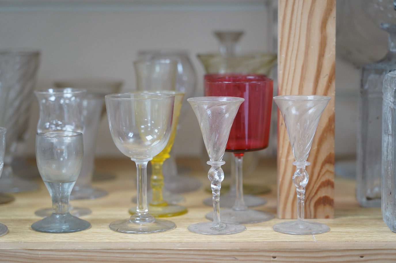 A large cut glass centrepiece, 26cm high, a pair of cut glass decanters and a collection of small glasses from 18th to 20th century. Condition - fair, difficult to see damage as most items need a thorough wash